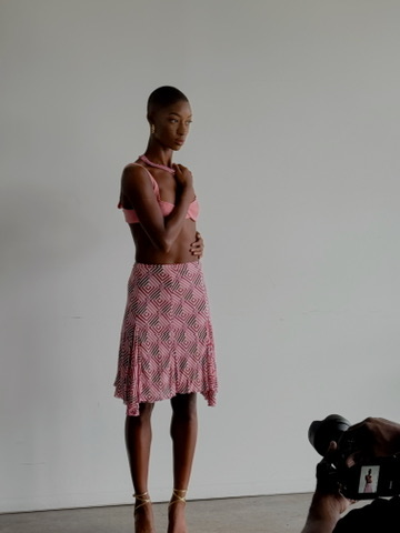 Model in a pink printed halter top and matching skirt