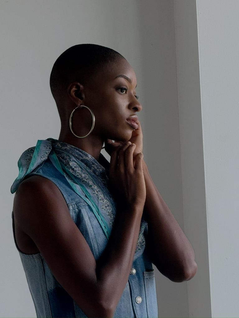 Portrait of a model in a denim vest with a printed silk scarf and hoop earring